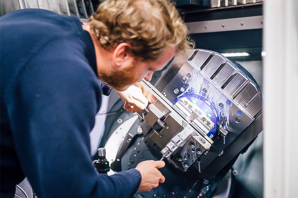 Ein Mitarbeiter bearbeitet ein Bauteil mit unserer hochmodernen CNC-Fräsmaschine.